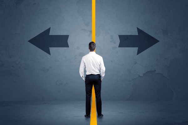 a man starting at a wall with a yellow line down the middle and arrows pointing left and right signifying Choosing Between Options